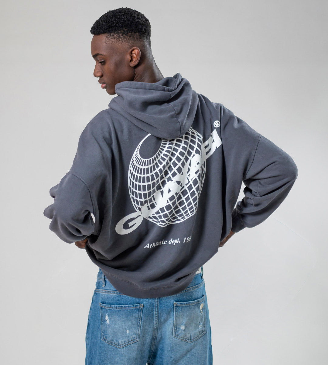 chico con sudadera con capucha color gris y dibujo de la expo sevilla guayabi